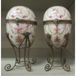 A pair of 20thC German lustre glazed porcelain egg ornaments, having applied gilt metal collars