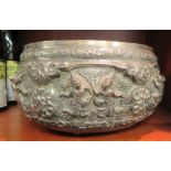 An Asian white metal bowl, cast and chased with traditionally attired dancing figures, floral and