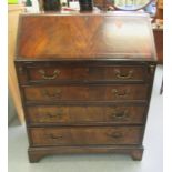A mid 20thC walnut finished bureau with a fall front, enclosing a fitted interior, over four