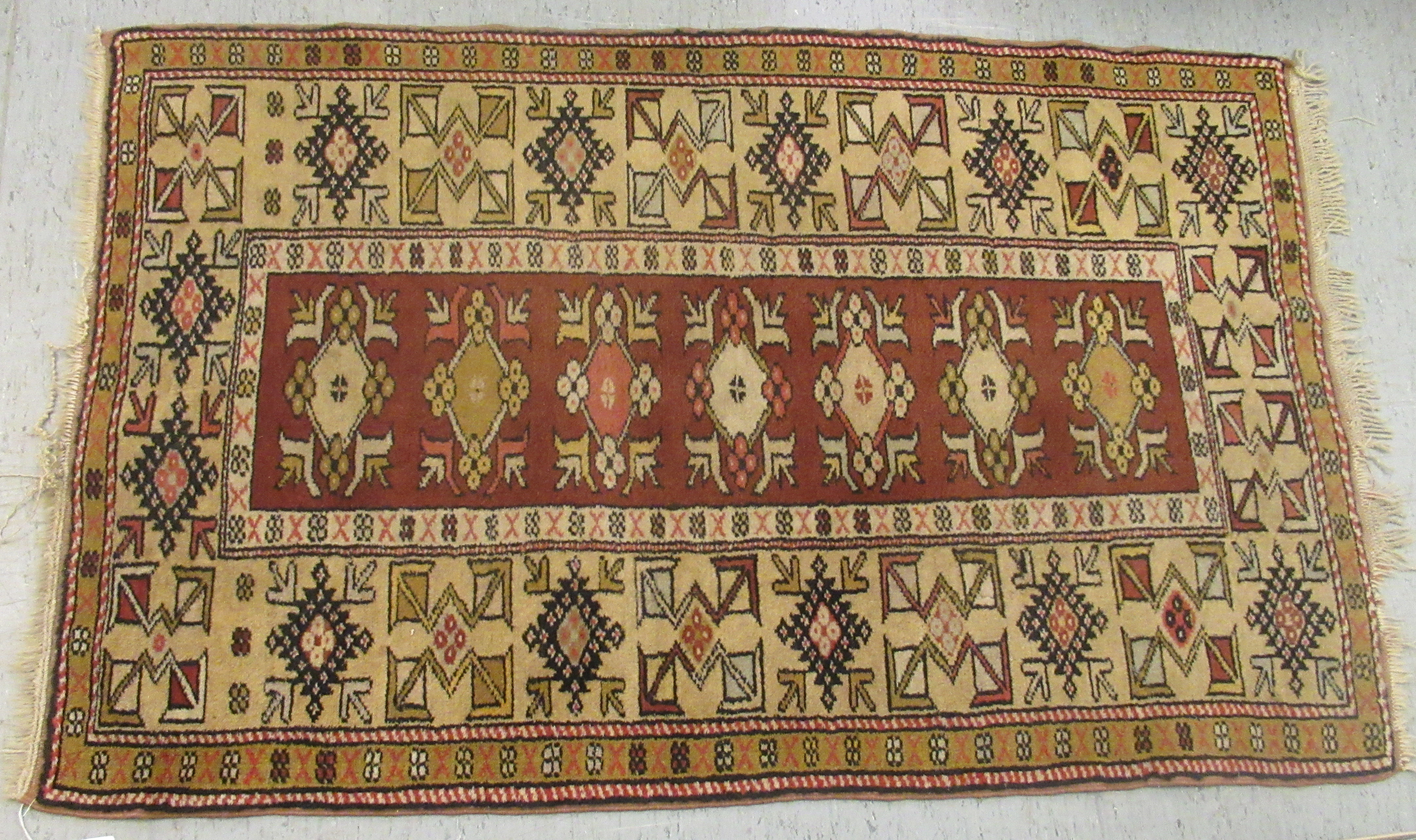 A patterned wool rug with geometric ornament, on an iron red ground  60" x 40"