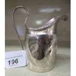 A Georgian silver oval cream jug with a high loop handle and scratch engraved ornament  London 1796