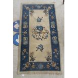 A 1950s/60s Chinese woollen rug, decorated with birds and flora with a blue border, on a cream