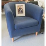 A modern tub style chair, upholstered in navy blue fabric with a cushion seat, raised on turned