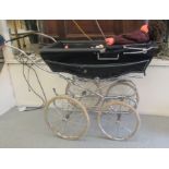 A mid/late 20thC Silver Cross coach built pram, on spoked wheels; and two celluloid dolls with