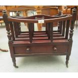 A late Victorian mahogany Canterbury with a divided section, over a base drawer, on turned legs
