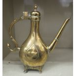 A 19thC Persian engraved brass coffee pot of bulbous form with a narrow neck, hinged lid, angled
