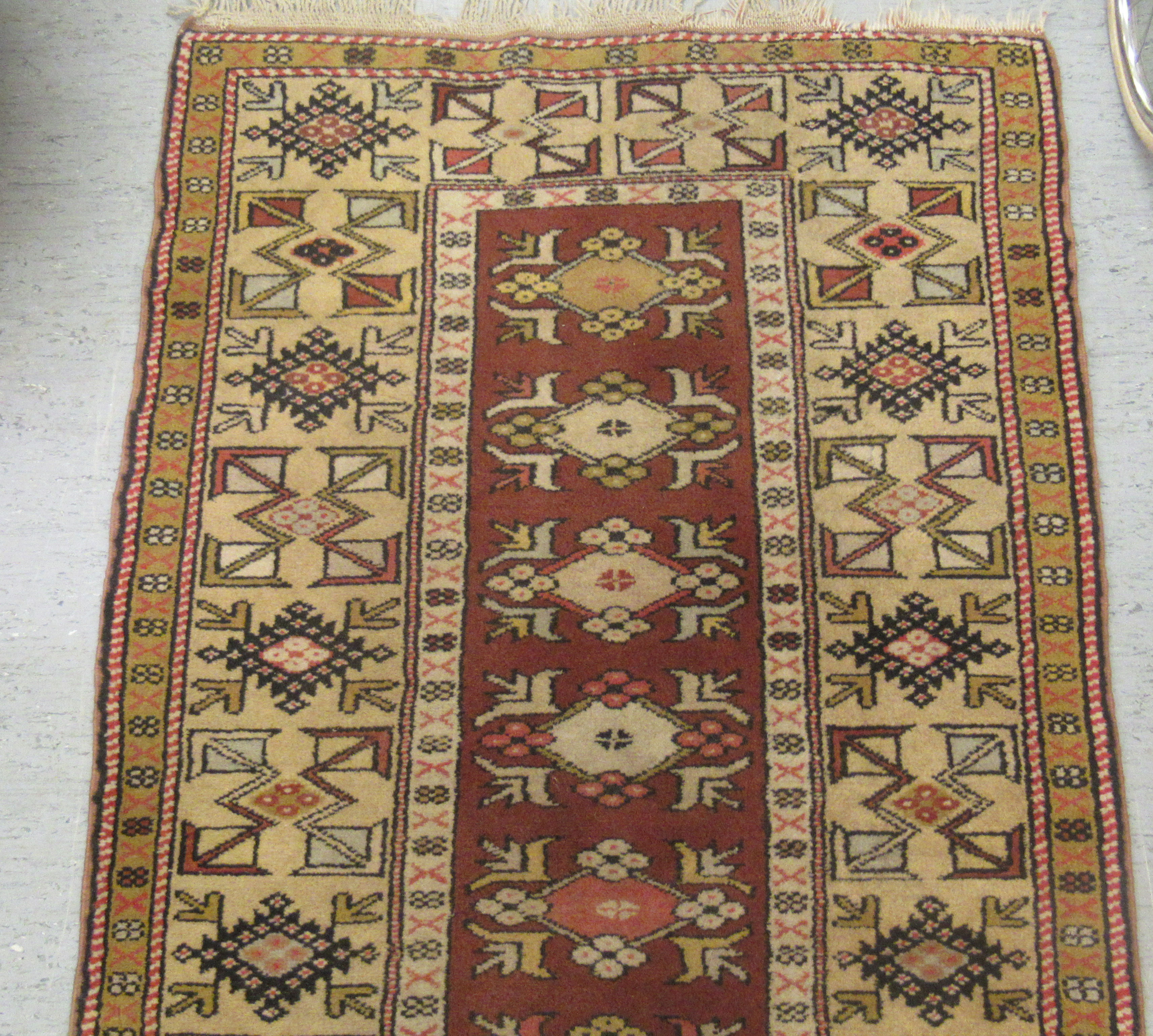 A patterned wool rug with geometric ornament, on an iron red ground  60" x 40" - Image 2 of 3