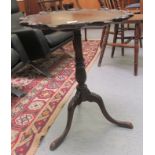 A mid 20thC mahogany finished wine table, the top with a carved serpentine outline, raised on a