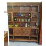 An early/mid 20thC carved oak dresser, the panelled back superstructure with glazed panelled doors