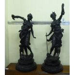 A pair of 20thC spelter figures huntress, on a stepped circular plinth  23"h