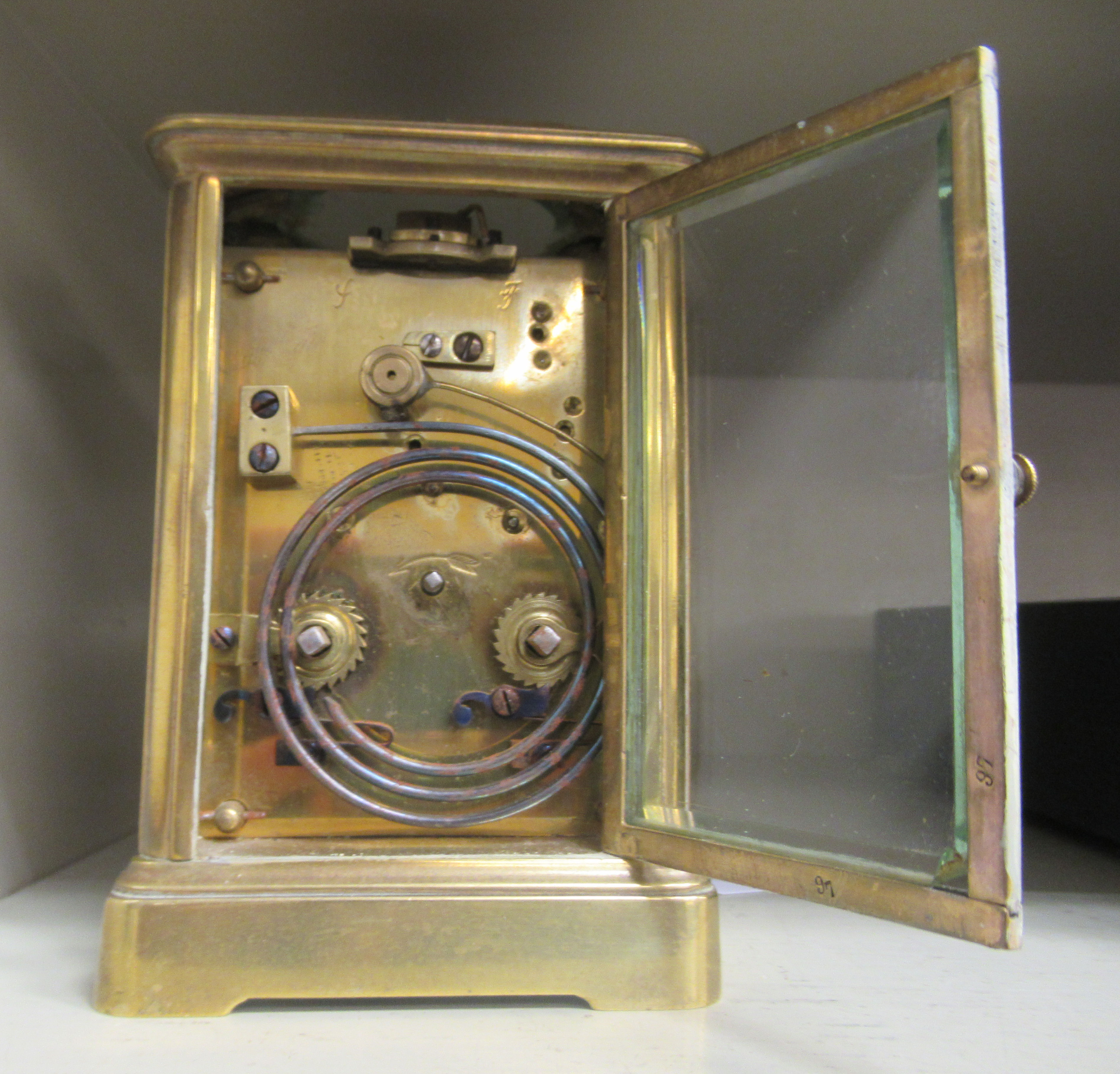 An early 20thC lacquered brass cased carriage clock with bevelled glass panels and a folding top - Image 3 of 3