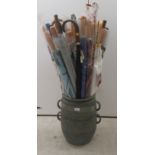 Modern walking aids and umbrellas, contained ; in a twin handled stoneware vase  17"h
