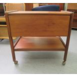 A 1970s G-Plan teak two tier drinks trolley, the top incorporating a pair of folding flaps, on