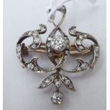 A yellow metal diamond set foliate scrolled pendant brooch