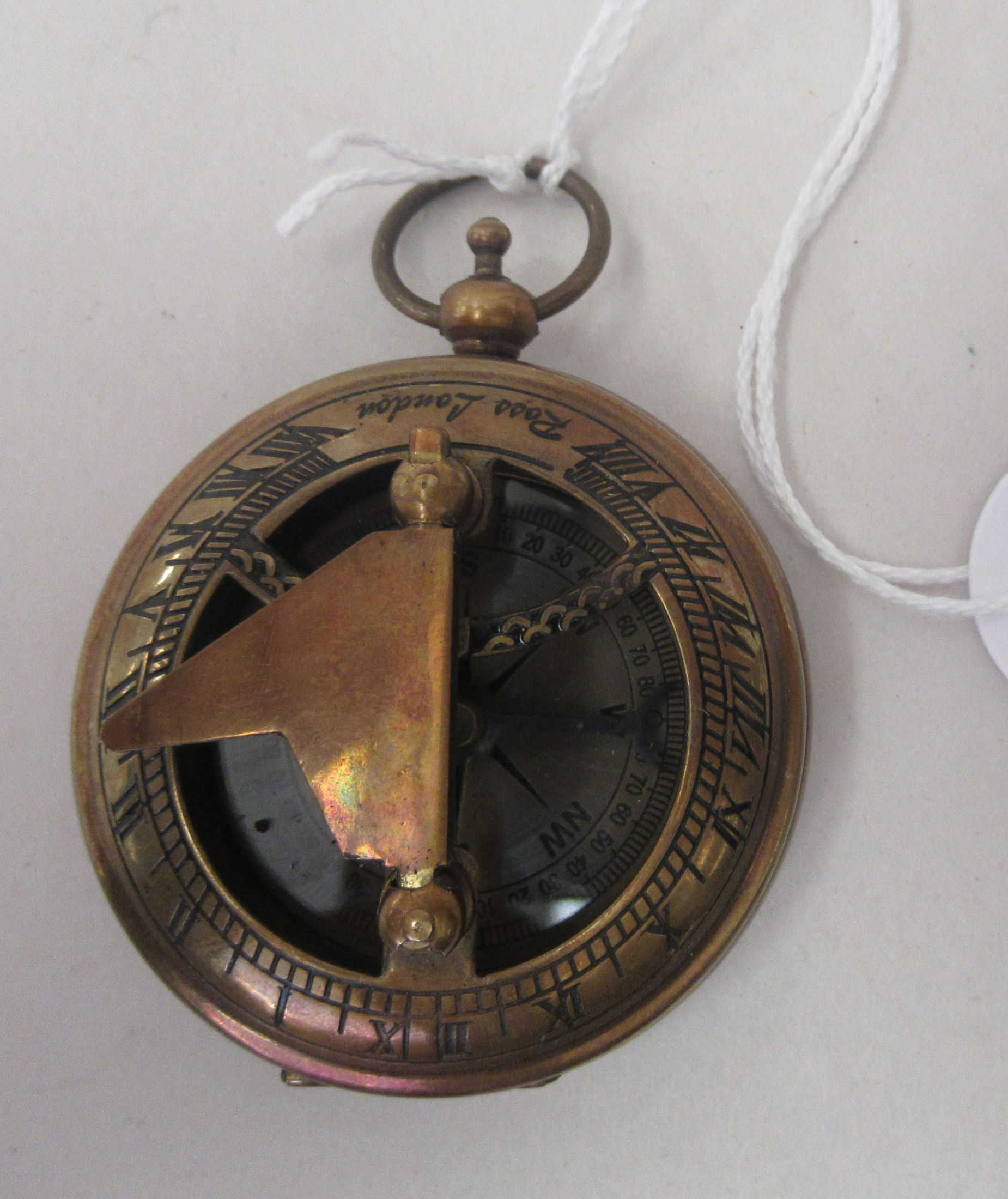 A lacquered and brass engraved brass cased pocket sundial/compass