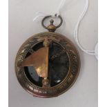 A lacquered and brass engraved brass cased pocket sundial/compass