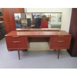 A 1970s Austin Suite teak dressing table, surmounted by a mirror, over two, two drawer pedestals,