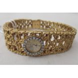 A ladies Omega 18ct gold bracelet wristwatch, designed by Gilbert Albert with a diamond set bezel