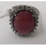 A white metal oval, ruby and diamond cluster ring