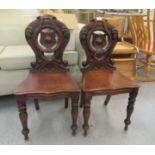 A pair of William IV mahogany hall chairs, the solid serpentine front seats, raised on turned,