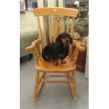 A modern light coloured beech framed Windsor, high lath back rocking chair with level arms and a