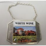 A silver coloured metal and enamelled White Wine label