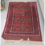 A Turkoman rug, decorated with stylised designs, on a red ground  49" x 67"