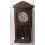 An early 20thC Continental, stained oak cased wall clock with a multi-glazed panelled door, the gong