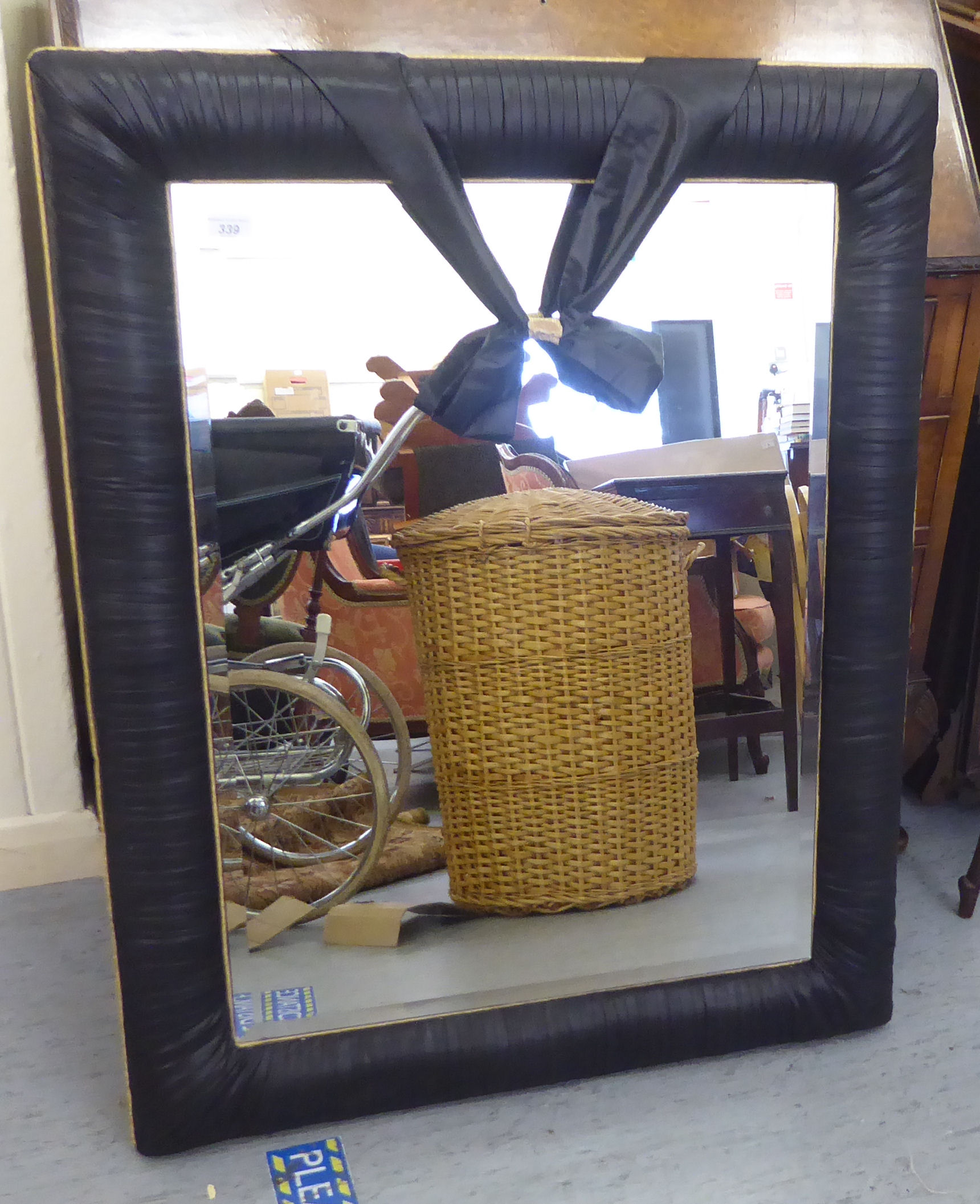 A modern mirror, the bevelled plate set in an overlapped black and gilt fabric frame  24" x 33"