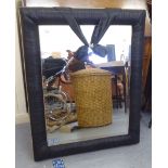 A modern mirror, the bevelled plate set in an overlapped black and gilt fabric frame  24" x 33"