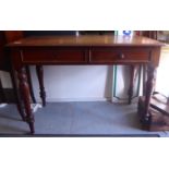 A late Victorian mahogany writing desk with two shallow drawers, raised on turned, tapered legs