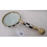 A lacquered brass and chequered black and white composition magnifying glass