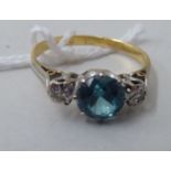 An 18ct gold ring, claw set with a central blue zircon, flanked by two diamonds
