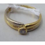 An 18ct bi-coloured gold single stone diamond ring