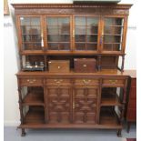 A mid 20thC carved oak dresser, the panelled back and pillared superstructure with four inline