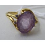 An 18ct gold ring, set with an amethyst, flanked by two pairs of diamonds