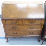 A mid 20thC walnut bureau, the fall front enclosing a fitted interior, over two short/two long