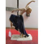 A Royal Dux gilded and painted porcelain dancer, wearing a midnight blue skirt,