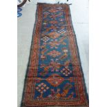 A Persian runner, decorated with repeating stylised designs, on a multi-coloured ground  24" x 124"