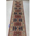 A Persian runner, decorated with repeating stylised designs, on a multi-coloured ground  22" x 86"