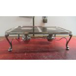 A silver plated warming plate with twin burners, raised on serpentine legs and bun feet  5"h  17"w