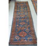 A Persian runner, decorated with repeating stylised designs, on a multi-coloured ground  34" x 124"