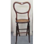 A child's late Victorian stained beech balloon back high chair with a woven split cane seat,