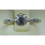 An 18ct gold single stone diamond ring with diamond chip shoulders