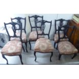 A set of four late Victorian ebonised salon chairs, each with a vase shaped splat, raised on