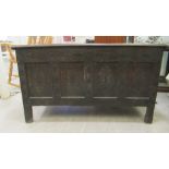 A late 18th/early 19thC four panelled oak coffer with straight sides and a hinged lid, raised