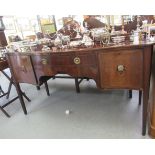 A Regency satinwood inlaid mahogany serpentine front sideboard, the back surmounted by a swan neck