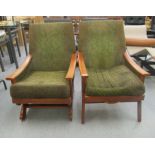 Two similar 1970s stained beech framed chairs with enclosed fabric arms, raised on splayed legs