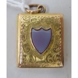 An engraved gold coloured metal book design locket, set with a heart shaped cornelian