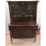 A William IV rosewood two part cabinet with a carved, bead bordered, breakfront cornice, over a pair